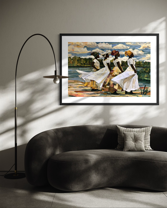 Framed fine art print depicting Afrocentric Gullah Geechee women dressed in white faux quilt-style patter dresses celebrating Black Lowcountry coastal heritage, African American ancestry, cultural traditions, family, community, and life rooted by the sea. Styled in a modern living room above a dark gray curved sofa with a black floor lamp.