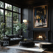 A luxurious dark living room featuring a black tufted chaise lounge, a round ottoman, a black coffee table, and a large framed Apollo Theatre fine art print on a black paneled wall above a fireplace.