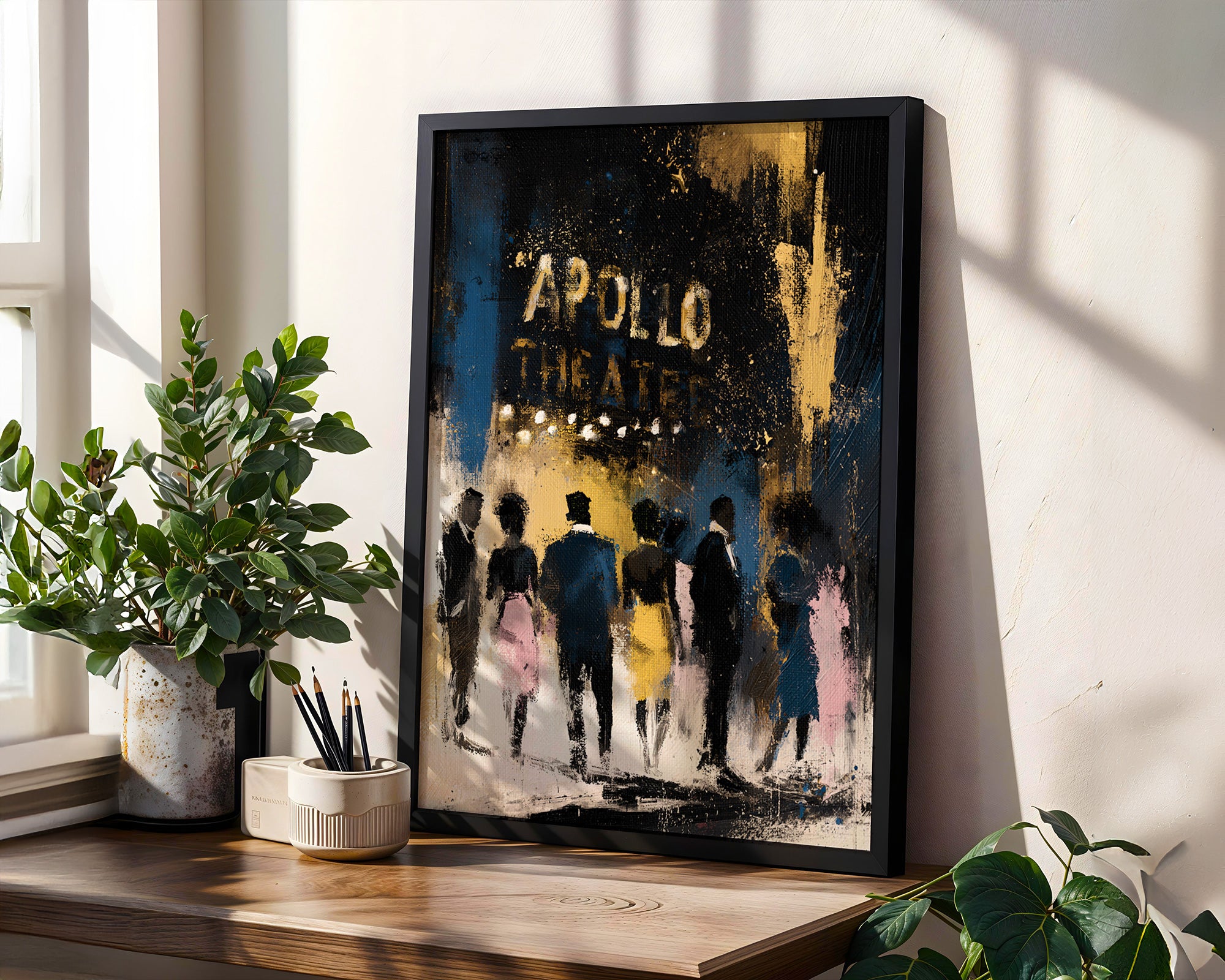 A framed art print leaning on a wooden windowsill in a bright room. The print features an abstract painting of figures walking towards the 'APOLLO THEATER' in distressed gold lettering.
