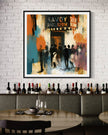 Framed art print of the historic Savoy Ballroom in Harlem displayed in a black frame with a white mat on a concrete brick wall in a stylish restaurant with wine bottles in the background.