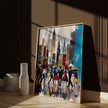 Abstract Afrocentric art print featuring Black silhouettes walking through rainy Manhattan streets with umbrellas and the New York City skyline in the background, displayed in a natural oak frame leaning against a warm brown wall as sunlight streams through a nearby window, casting soft shadows across the artwork.