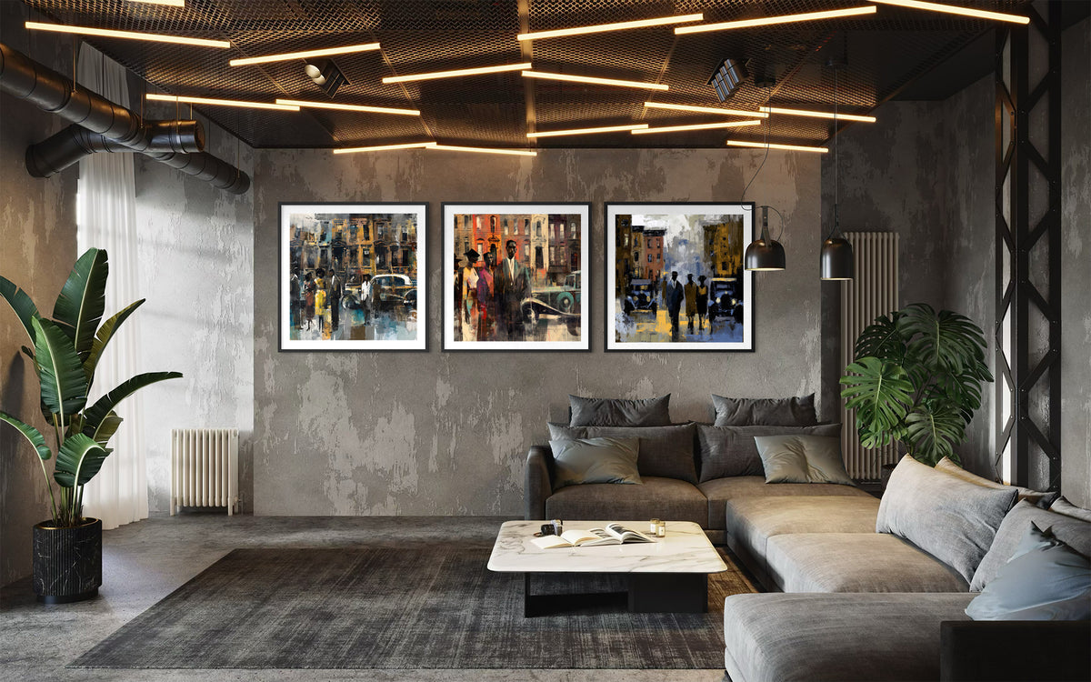 Three framed Harlem vintage styled art prints depicting colorful city street scenes, displayed in a modern industrial loft living room setting above a gray sectional sofa.