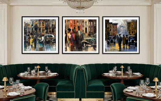 A staged restaurant interior with three framed Harlem vintage city street art prints hanging above a curved dark green velvet booth and tables set with glassware and lamps.