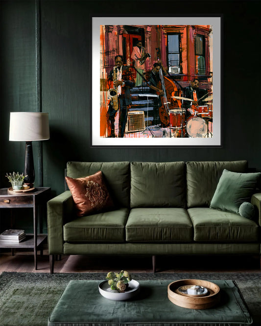 A framed abstract painting of a Black jazz band playing in front of a brownstone building, displayed on a dark green wall above an olive green velvet sofa in a modern living room setting.