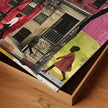 Abstract Afrocentric art of a Black man and woman taking a quiet stroll past historic Harlem brownstones. The scene highlights a sunny stoop and captures the peaceful rhythm of neighborhood life, evoking warmth, heritage, and cultural pride.